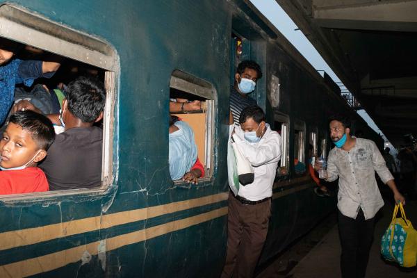 People gather at the Kamalapur Railway Station as they leave Dhaka a day before the government imposes a countrywide lockdown following an increase of COVID-19 cases in Bangladesh.