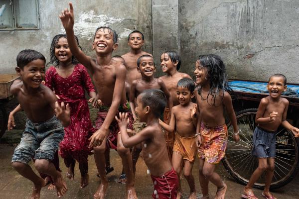 Kids are playing on the street of Dhaka, Bangladesh during the rain.