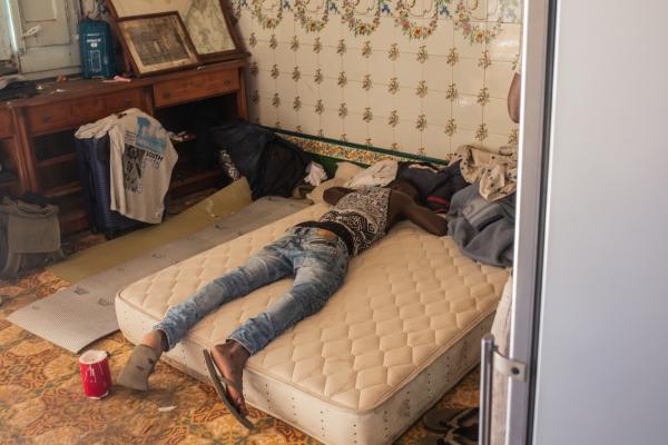   Un joven duerme en un colchón en el salón de ’La cueva de Batman’. Los salones son el lugar donde las personas que no tienen habitación propia en las naves o los pisos pueden descansar.  