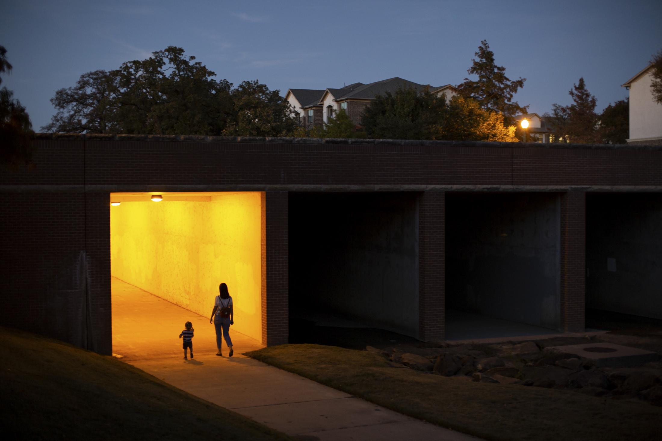 A mother and child take an evening walk during the 2020 COVID-19 Pandemic. Keller, Texas, many...