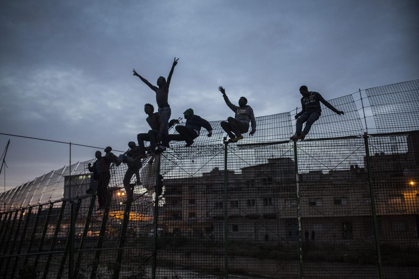 Thumbnail of Sub-Saharan migrants climb over _uta. (&copy; Santi Palacios)