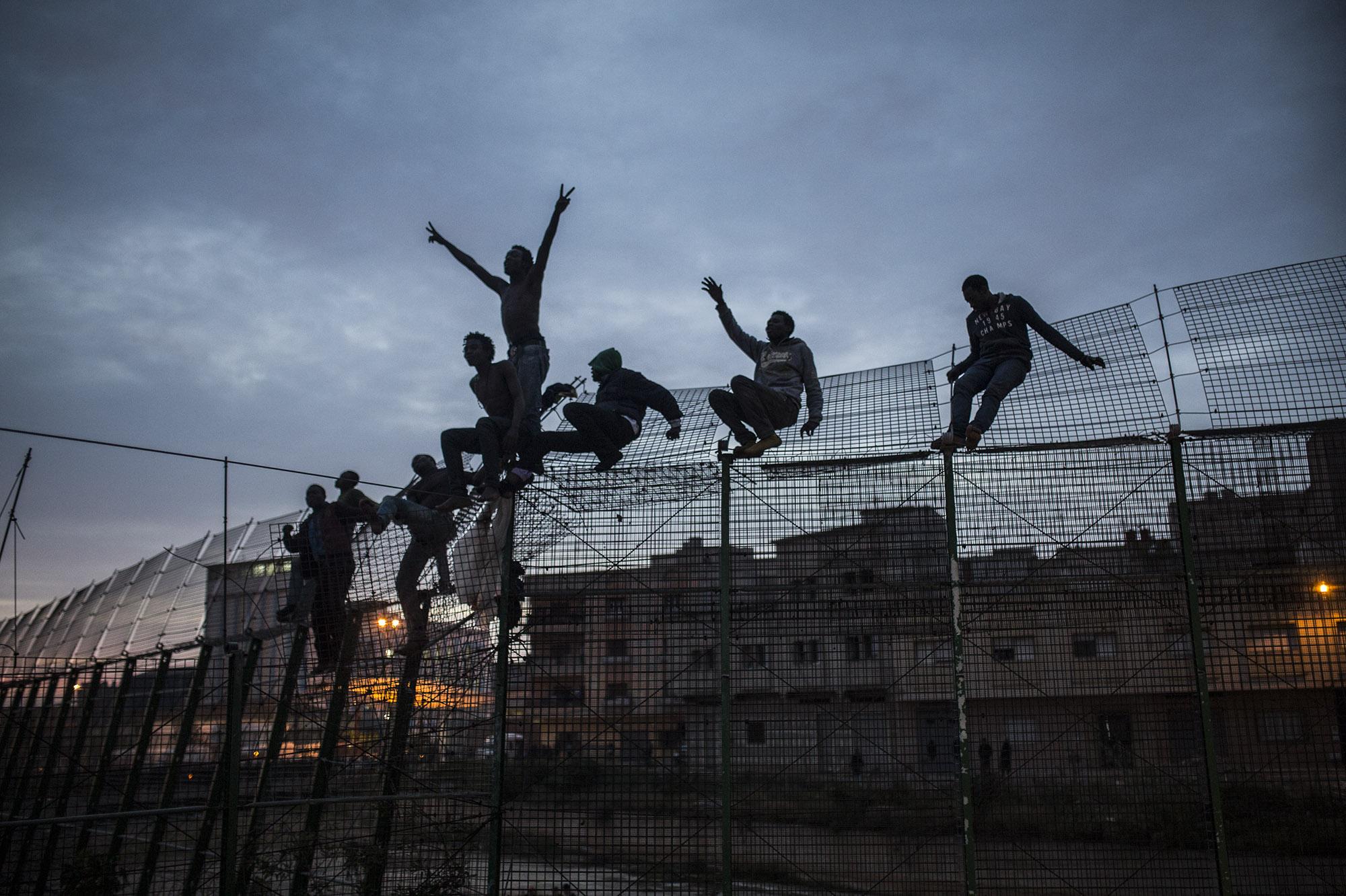 Sub-Saharan migrants climb over a metallic fence that divides Morocco and the Spanish enclave of Melilla on Friday March 28, 2014. Several hundred African migrants tried to cross barbed-wire border fences to enter the Spanish enclave of Melilla from Morocco but most were blocked by Moroccan police or pushed back by the Spanish Guardia Civil as a handful managed to remain in European soil. In early 2014 thousands of migrants seeking a better life who couldn&#39;t afford to pay to cross the Mediterranean sea aboard a rubber raft to get to Europe, were living illegally in the forests of north Morocco hoping they could enter Melilla and Spain&#39;s other north African coastal enclave, Ceuta. (&copy; Santi Palacios)