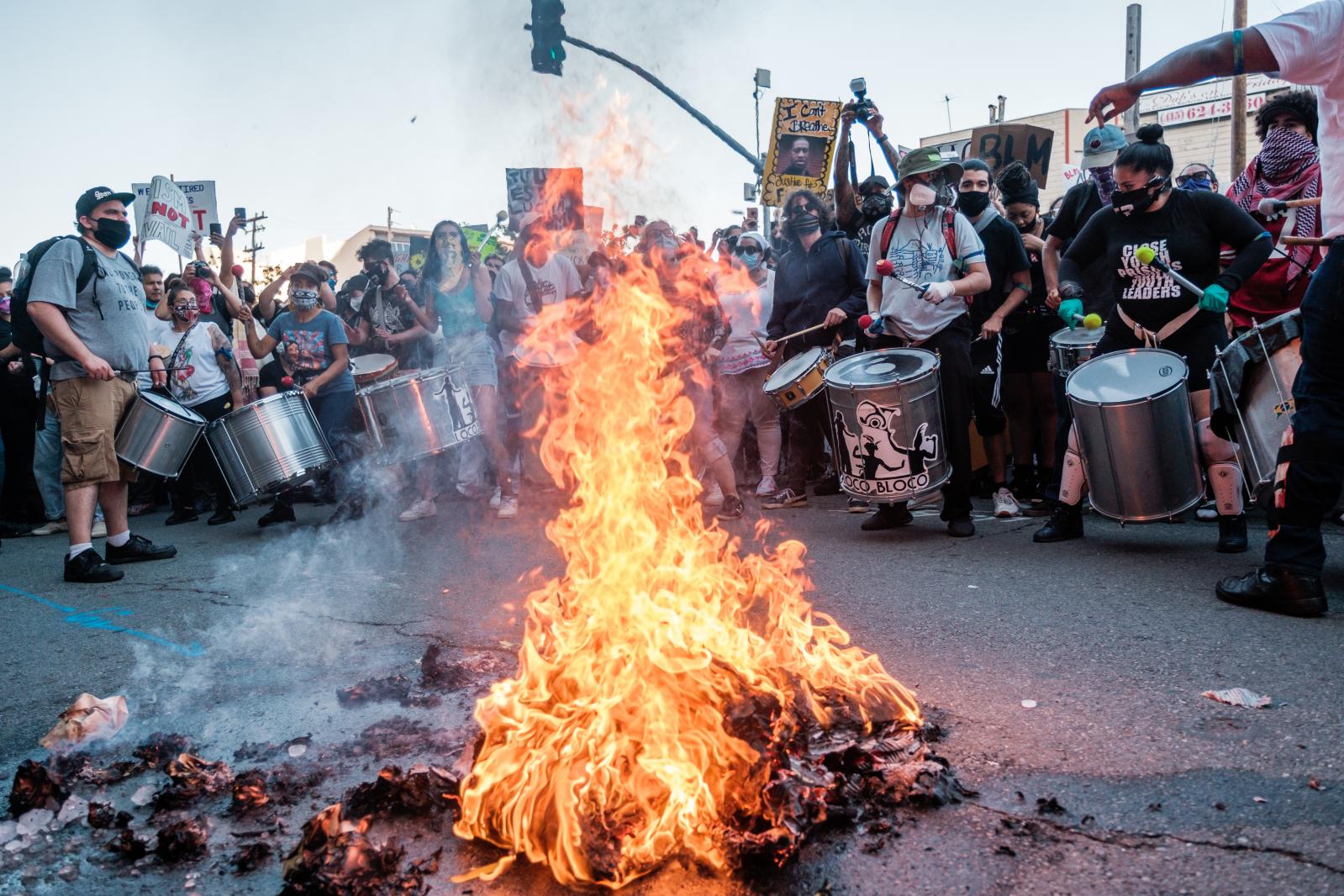 Image from NEWS - People drum and dance around a small fire at the end of a...