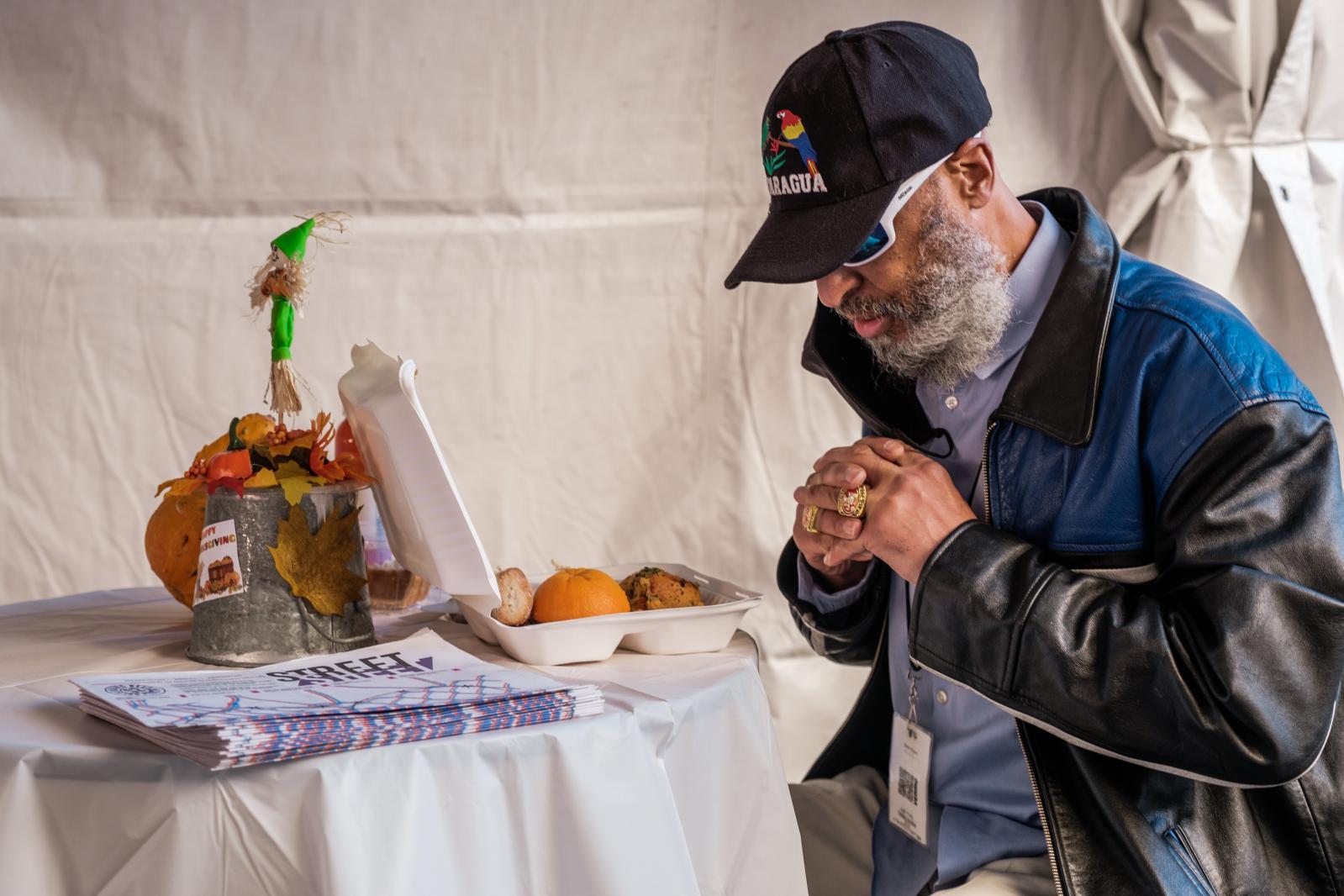 Sterling Valentine prays over his Thanksgiving meal provided by Glide in San Francisco on Thursday, November 26, 2020. Glide moved their annual Thanksgiving meal service outdoor this year because of the ongoing pandemic.