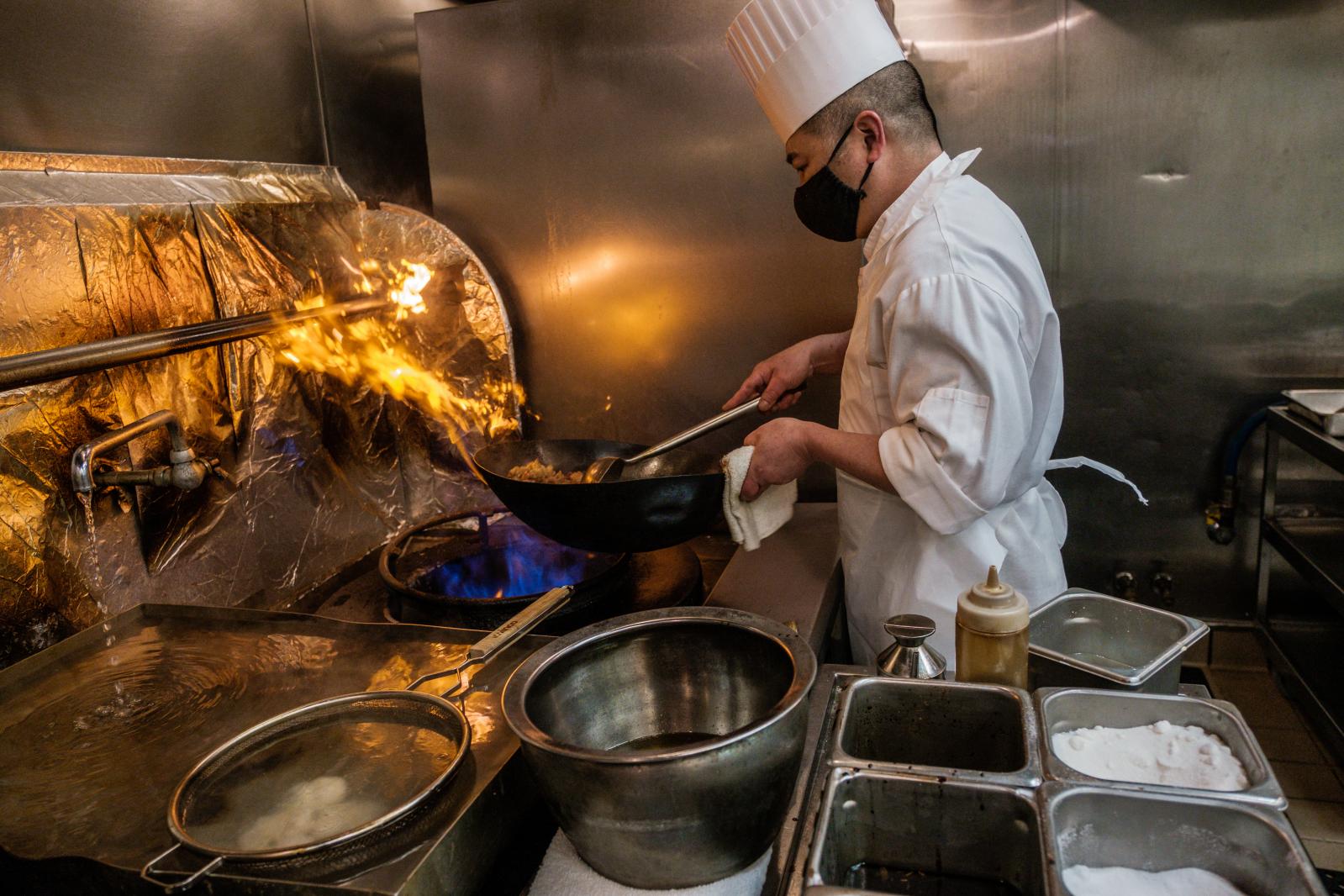 Image from FOOD/DRINK - Chef Chao Hua Lei prepares a dish using a gas stove at...