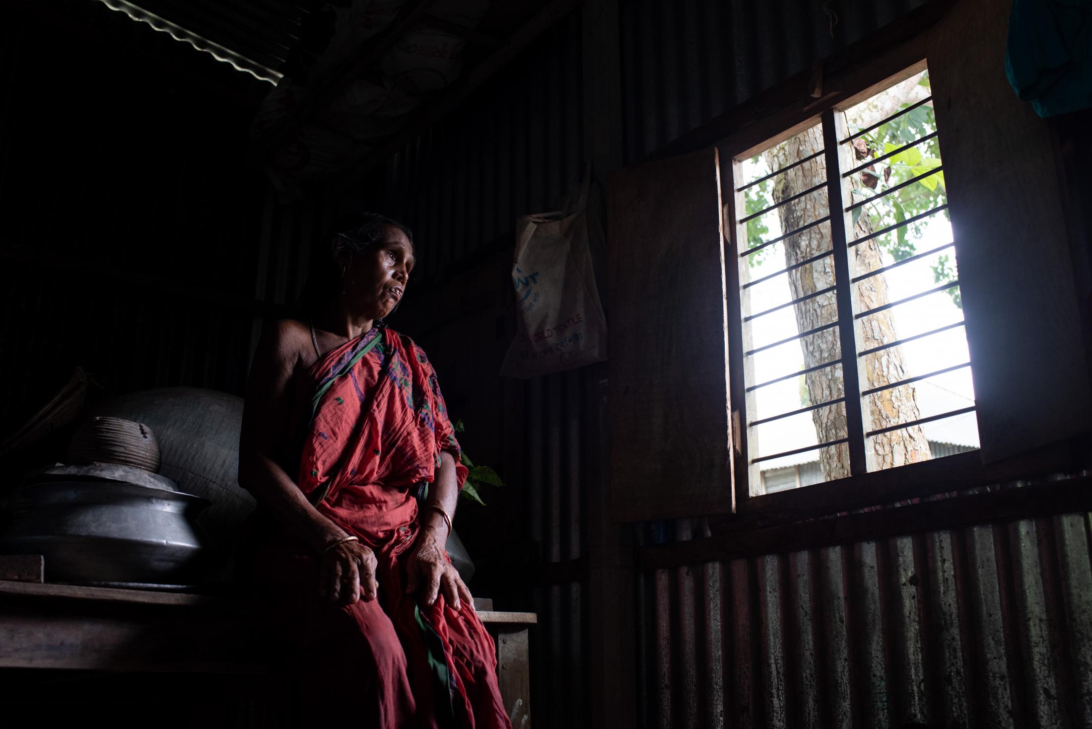 The Depth of Flood - A flood-affected woman sits sadly inside her house in...