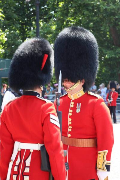Joy - In Photos  - One of the Queen&#39;s Guards makes the other smile, a brief pause from their typically stoic...