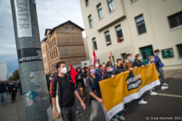 HALLE, GERMANY - OCTOBER 3: Protesters block a street in the city centre as part of a counter demonstration held by &#39;Halle against the Right&#39; against supporters of the &#39;Querdenken&#39; movement and members of the far-right who were marching and protesting against Angela Merkel, under the loose and contradictory title of &#39;Geil Merkel,&#39; on German Unity Day on October 3, 2021 in Halle, Germany. Merkel is in Halle today to attend Unity Day celebrations. Unity Day marks the reunification of Germany in 1990 following its division between West Germany and East Germany during the Cold War. (Photo by Craig Stennett/Getty Images)