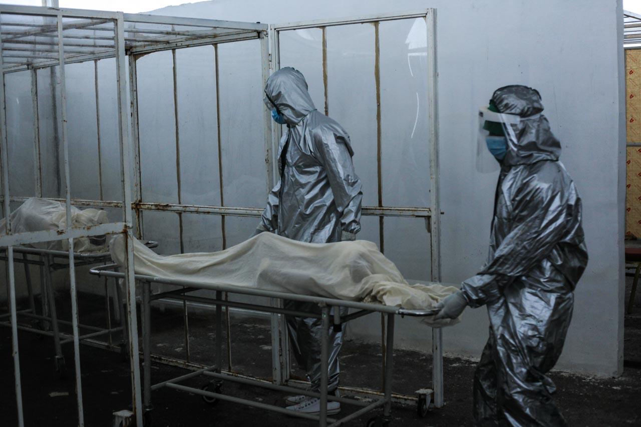  Morgue workers in personal protective suits (PPE) put the body of a COVID patient into a cage. &ldquo;... [We have been] covering at least 6 dead bodies every day for the past 3 months. The worst part is that now we are detached &nbsp;from our emotions and feelings. At first we used to cry and feel sad when relatives came and were grieving &nbsp;but now it&rsquo;s like we are robots in PPE suits. We don&rsquo;t feel anything. The only thing we have now is hope that one day this will be over and we will be out and be human again.&rdquo; 