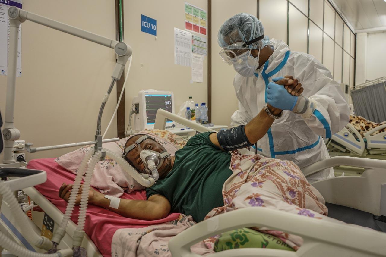  &ldquo;Hold my hands for my last breath&rdquo;. A medical worker holds the hand of a dying patient infected with COVID-19 at Millennium Hall 