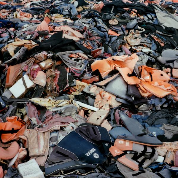 Image from In the Name of God -   Tens of thousands of discarded life jackets lying in...