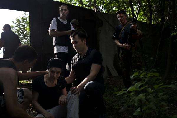 Ukraine Crisis-The East - Donetsk people militia men, helping a civilian who was...