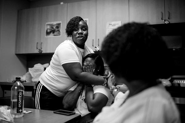Two mothers, whose sons where murdered on the streets of the 5 boroughs of NY,embrace each other, during the monthly meeting of "Not Another Child" an organisation founded by a mother who lost her child to gun violence, her organsation collaborates with ManUp Inc and supports the mothers...some of them are from E New York.