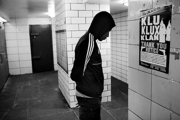 A resident of Linden houses reads a sign the was put by ManUp Inc in the building entrance: "The KKK would like to take this time to salute and congratulate all gangbangers/shooters, for the daily slaughter of thousands of people of colour each year. you are doing a marvellous job. keep killing each other for nothing......"