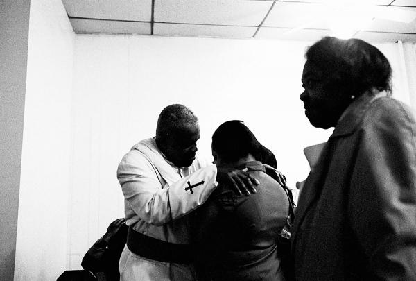 Reverend Kevin Jones of Peterson Temple Ministries comforts one of his congregants during a Sunday church service. Jones began the Clergy Action Network and works closely with S.O.S. to help reduce gun violence on the streets of Crown Heights.
