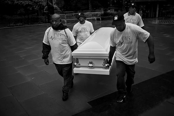 Members of different Cure Violence teams in NY, carry a white empty coffin to the press conference in city hall NYC, marking the beginning of gun violence awareness month in NY.