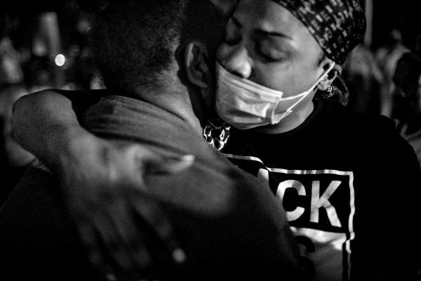 During an Occupy Corner event in Flatbush organized by The God Squad and East Flatbush Village, Ticia Smith (L) is comforted by a member of her community after telling the story of her brother's murder.
