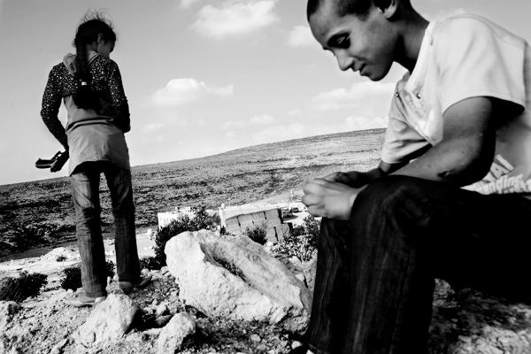 Children from Ar Ramadin village, looking at Palestinians who cross back &quot;illegally&quot; into the West Bank, &nbsp;after a working week in Israel, at the outskirts of Ramadin village. The 5 kilometres area of what used to be the 1967 border line fence just outside the village was notoriously easy to slip through. in 2017, Israel finished constricting the barrier in those 5km.