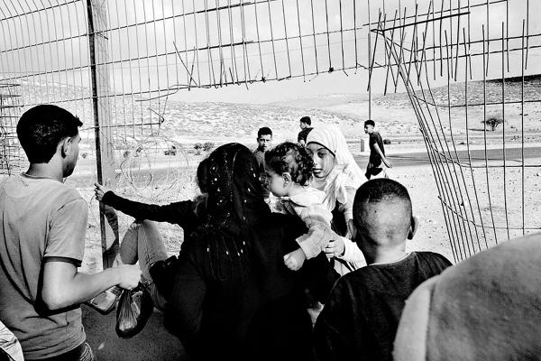 A Palestinian family cross illigaly into Israel, via a gap in what used to be the 1967 border line fence. Ar Ramadin Village, South Mt Hebron, West Bank. The 5 kilometres area of just outside the village is notoriously easy to slip through from the West Bank into Israel.