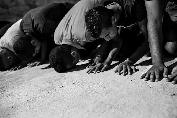 Members of Ar Ramadin tribe praying outside one of the village mosques, a destruction notification from the Israeli authorities on the pretext of illegal building of the mosque, was issued. Eventually the Sheikh of the village was able to push back the warrant, by talking to the Israeli authorities and the mosque remained in place. Ar Ramadin Village, South Mt Hebron, West Bank.   