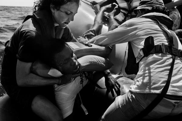 Image from On Strange Waters - Sea Watch crew evacuate a refugee from Darfur, after he...