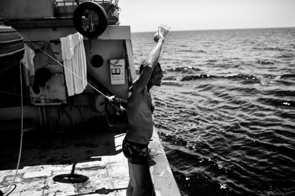 A member of Sea Watch, washing himself with water after a long day of refugees rescues off the Libyan cost.