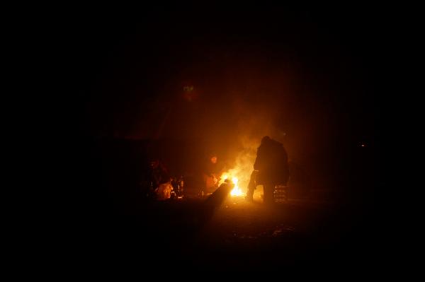 Image from Stranded - Belgrade/Serbia - Refugees warming themselves by a fire,   inside a...