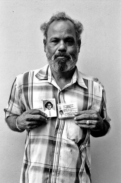 A Tamil man holds pictures of his son and daughter , who were abducted by unknown assailants during the conflict. Trincomalee, East Sri Lanka.