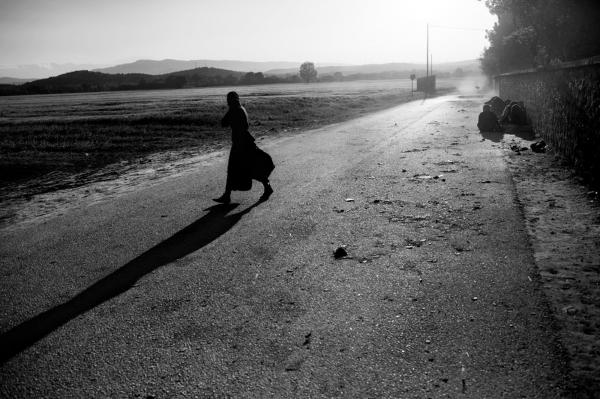 Image from Stranded - Idomeni/Greece - A refuge walks inside the camp, during a morning sand storm.