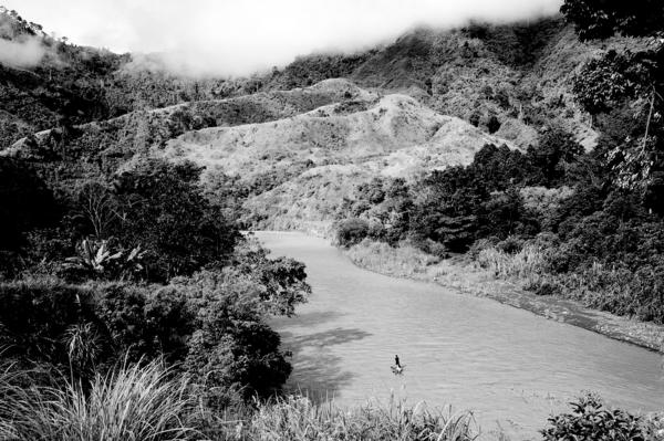 Matigasalug Manobo man crosses a river on his way back home, Mindanao.