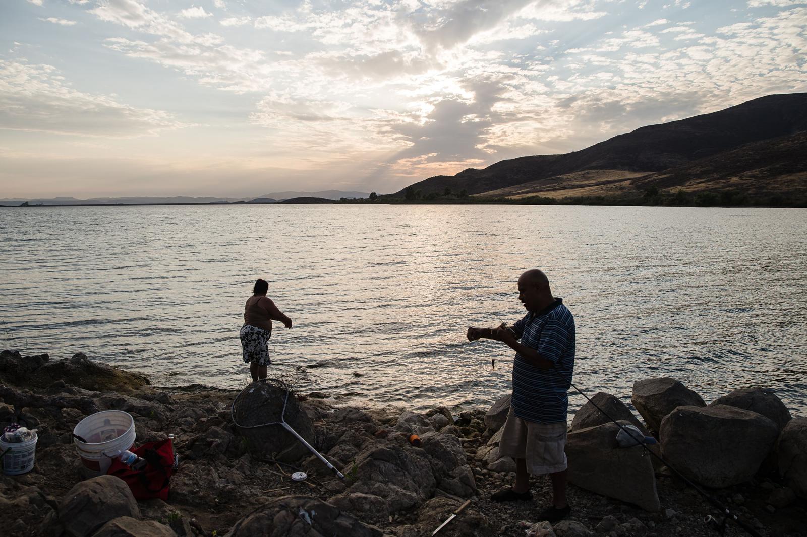 Jose Batras fishes while his wife Maria Estrada helps him at Lake Skinner in Winchester, California on August 11, 2021. Lake Skinner is around 80 percent full. Wheras across Northern California reservoirs are at low levels.
