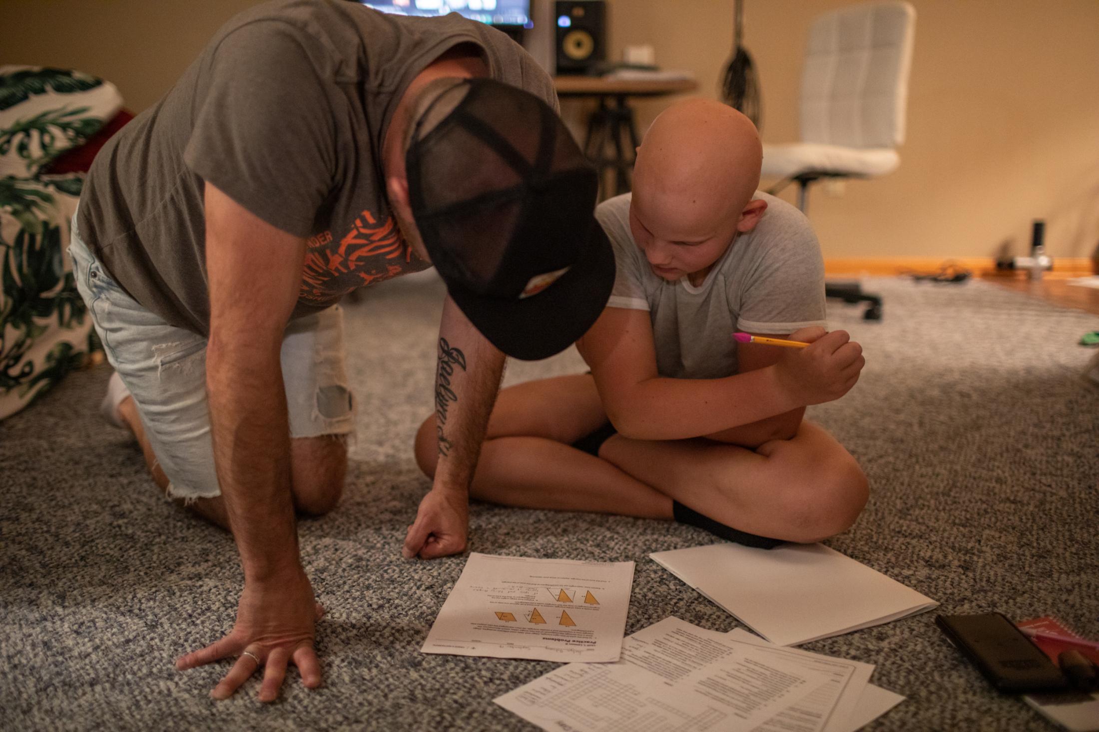 After dinner Jaylan finishes her homework with the help of her dad, South Portland, Maine,...
