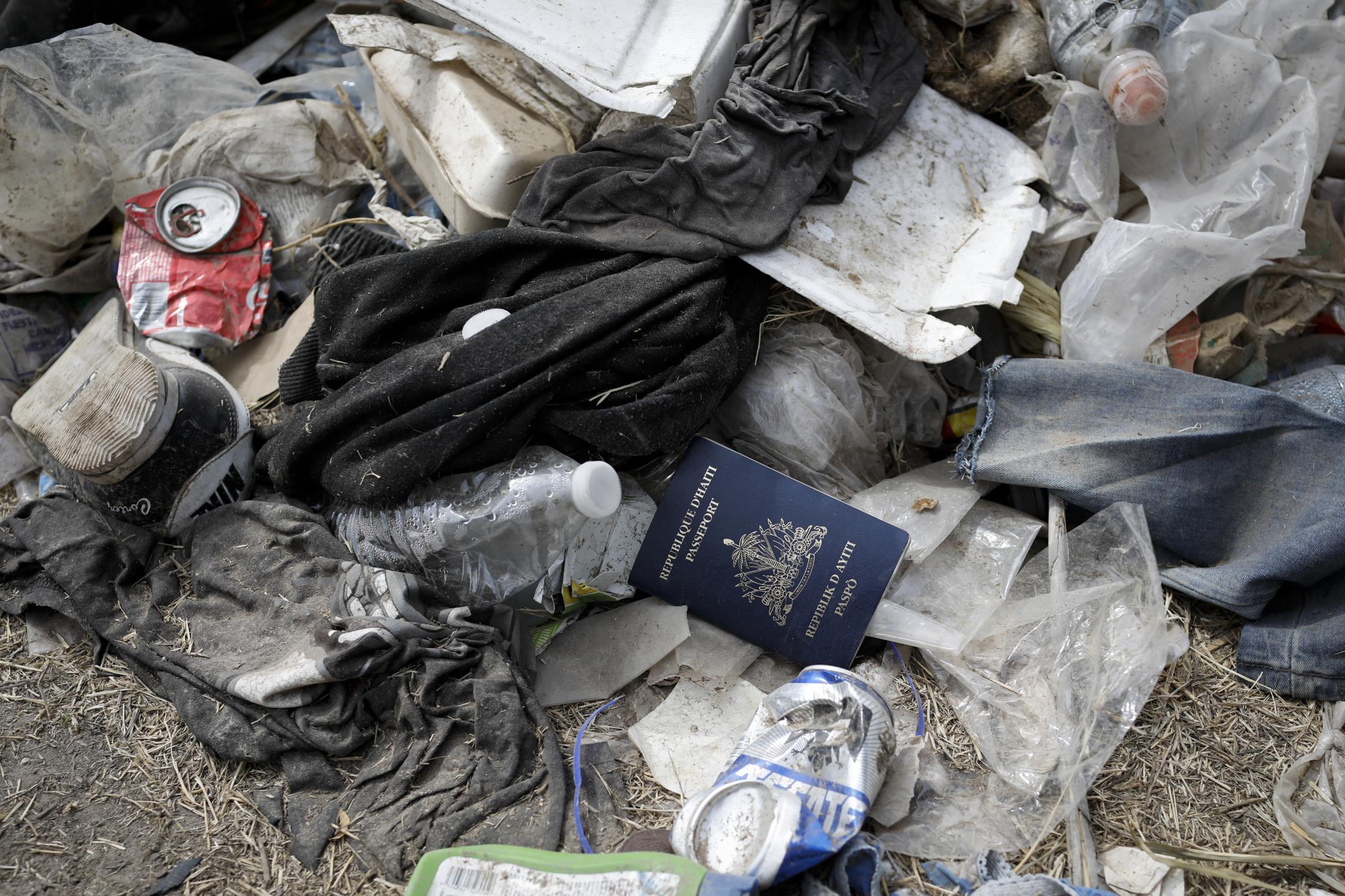 A Haitian passport is seen in a pile of trash near the International Bridge between Mexico and the U.S., where migrants seeking asylum in the U.S. are waiting to be processed, in Del Rio, Texas, U.S., September 21, 2021. REUTERS/Marco Bello