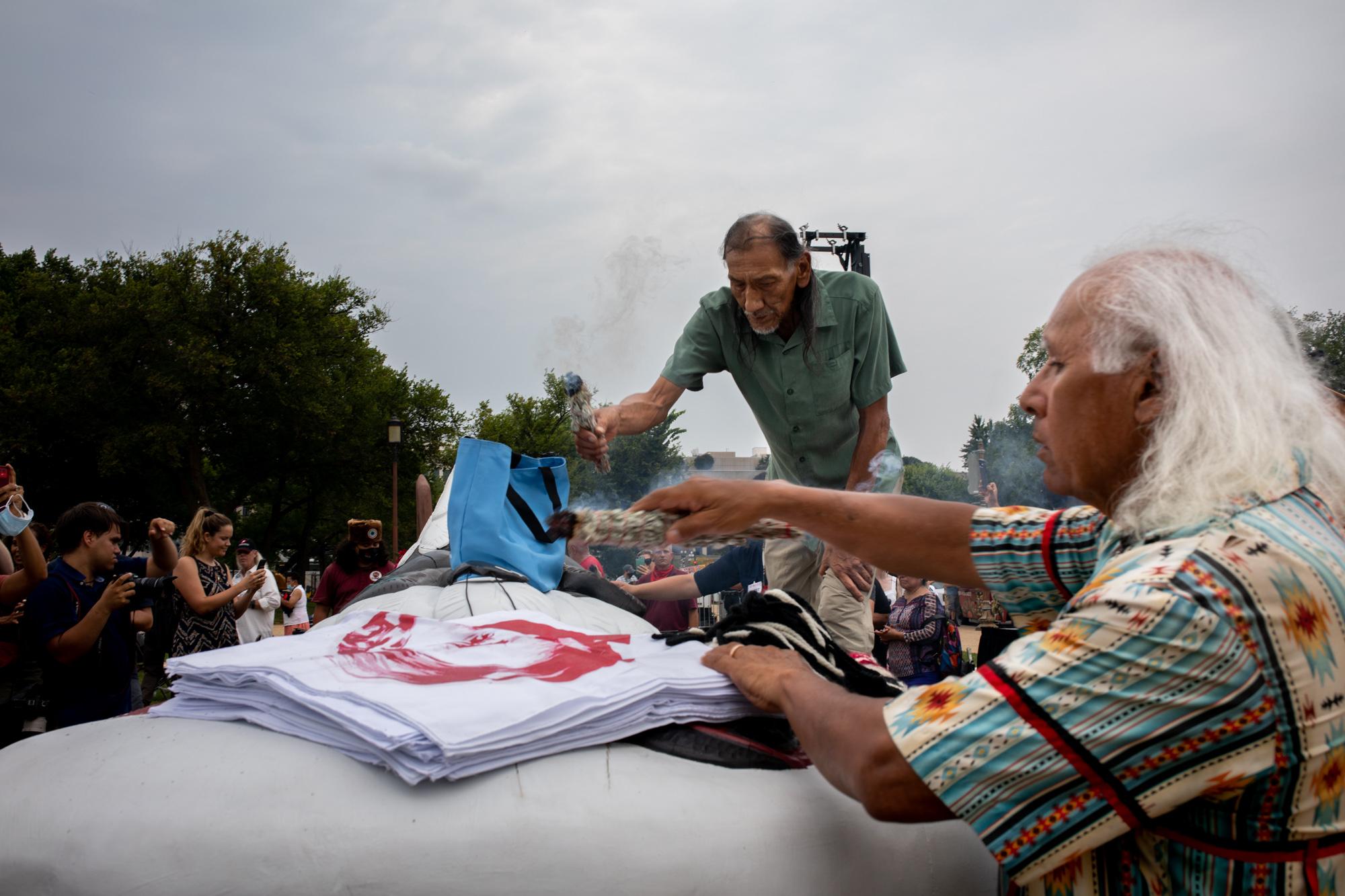 (Left) Elder Nathan Phillips of the Omaha Nation and Alan Salazar of Fernandeno Tataviam Band of Mission Indians bless the hand carved totem pole in the National Mall in Washington, D.C. Thursday, July 29, 2021 Commissioned for The New Republic 