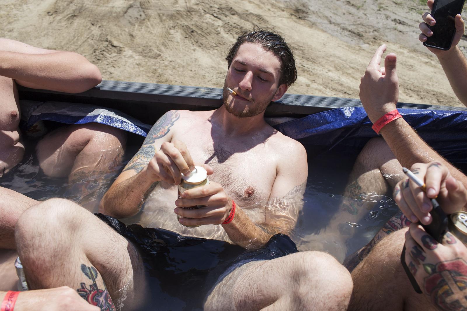 Alic Scoat drinks a beer in a pool made out of a pickup bed during Audiofeed Festival in Urbana,...