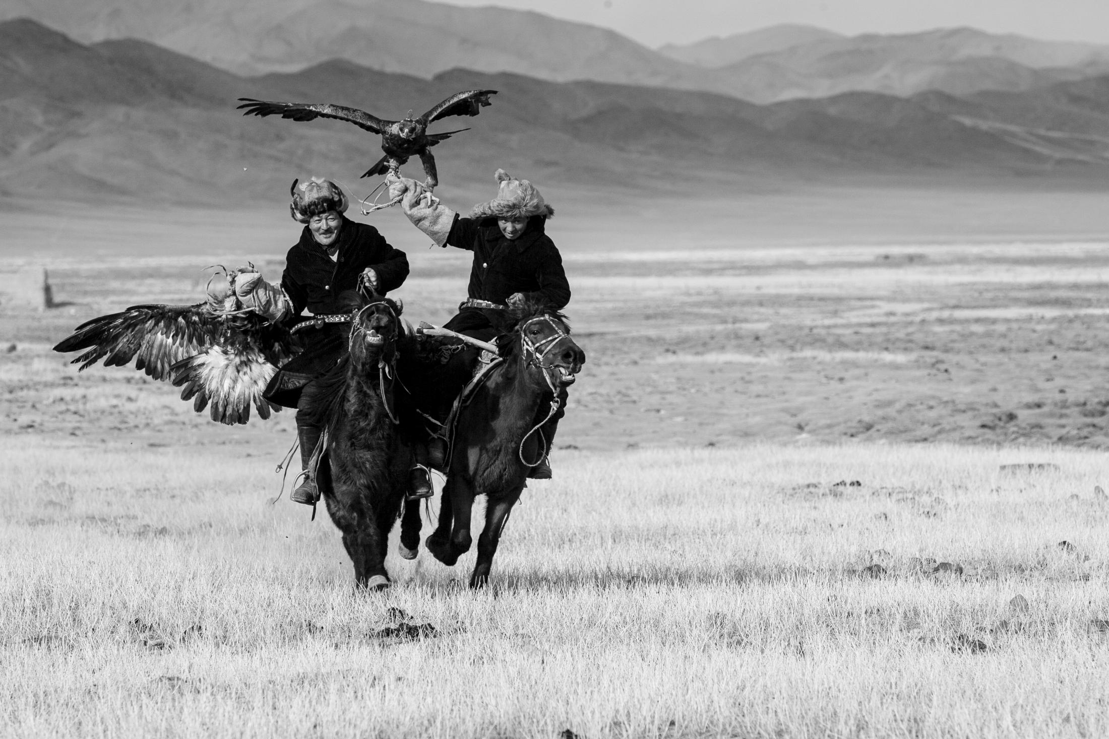  Proud horsmen.&nbsp; The roots of the Kazahk people can be traced back to the 15th century and to Chengis Kahn. The Kazahk minority settled in the Altai mountains in the 19th century after fleeing the Russian Empire for fear of it ending their nomadic lifestyle. The horse is still their primary means of transportation. Here the hunters are on their way home after hunting training.