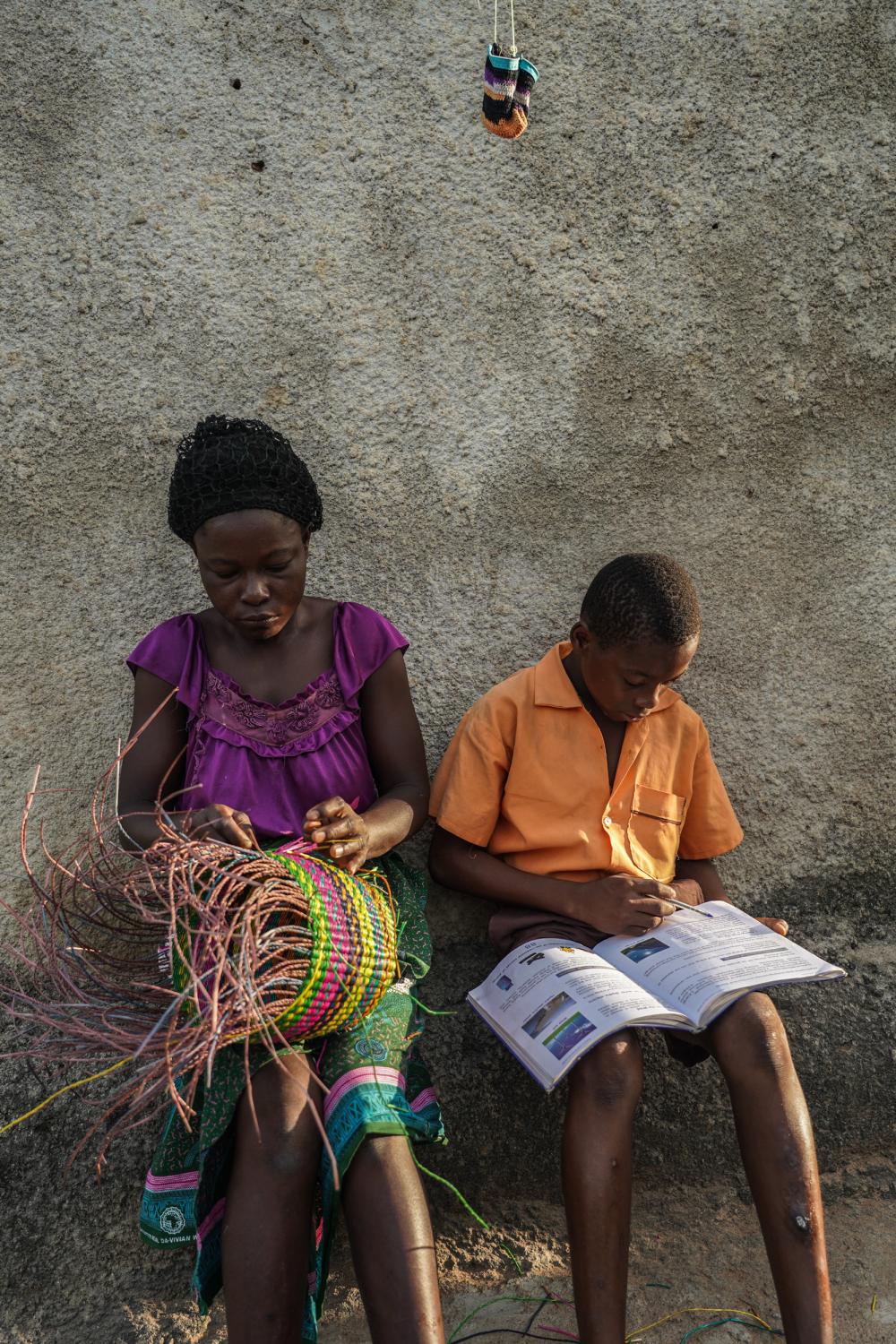 Tales Under the Baobab Tree - Timothy Nsobila (13) does his homework while his mother...