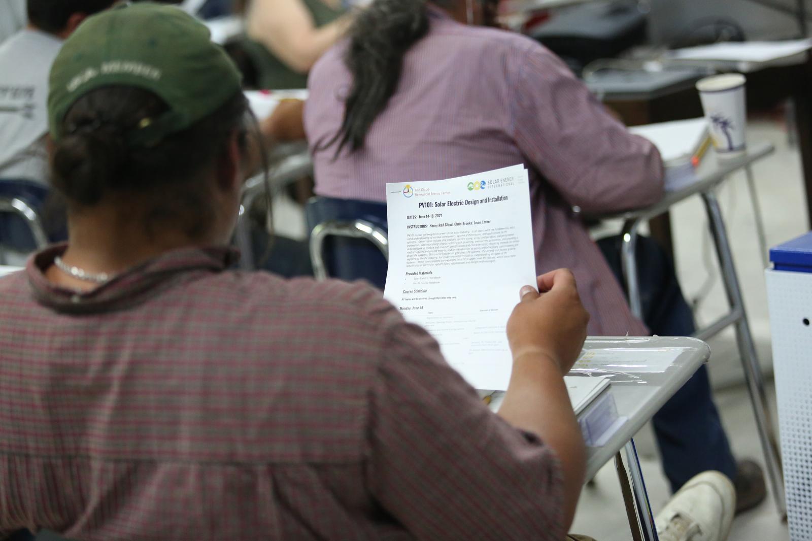 Student Gwe Gasco looks at a course handout on the Pine Ridge reservation in South Dakota, U.S., June 13, 2021. Picture taken June 13, 2021. REUTERS/Emilie Richardson