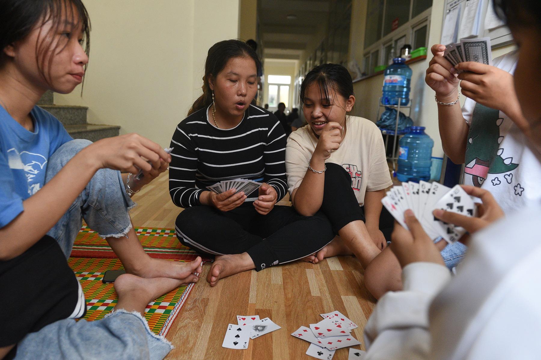 A month with full of sorrow - Girls play cards in a shelter as Typhoon Molave lashes...