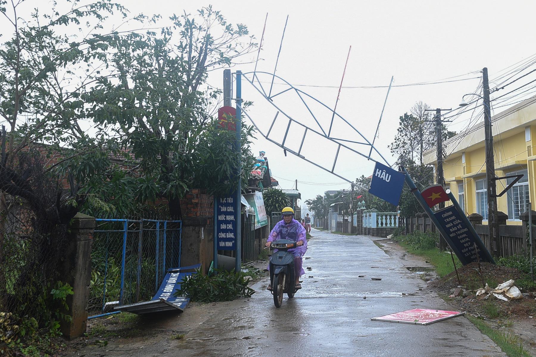 A month with full of sorrow - A man bikes past a broken sign as the Typhoon Molave...