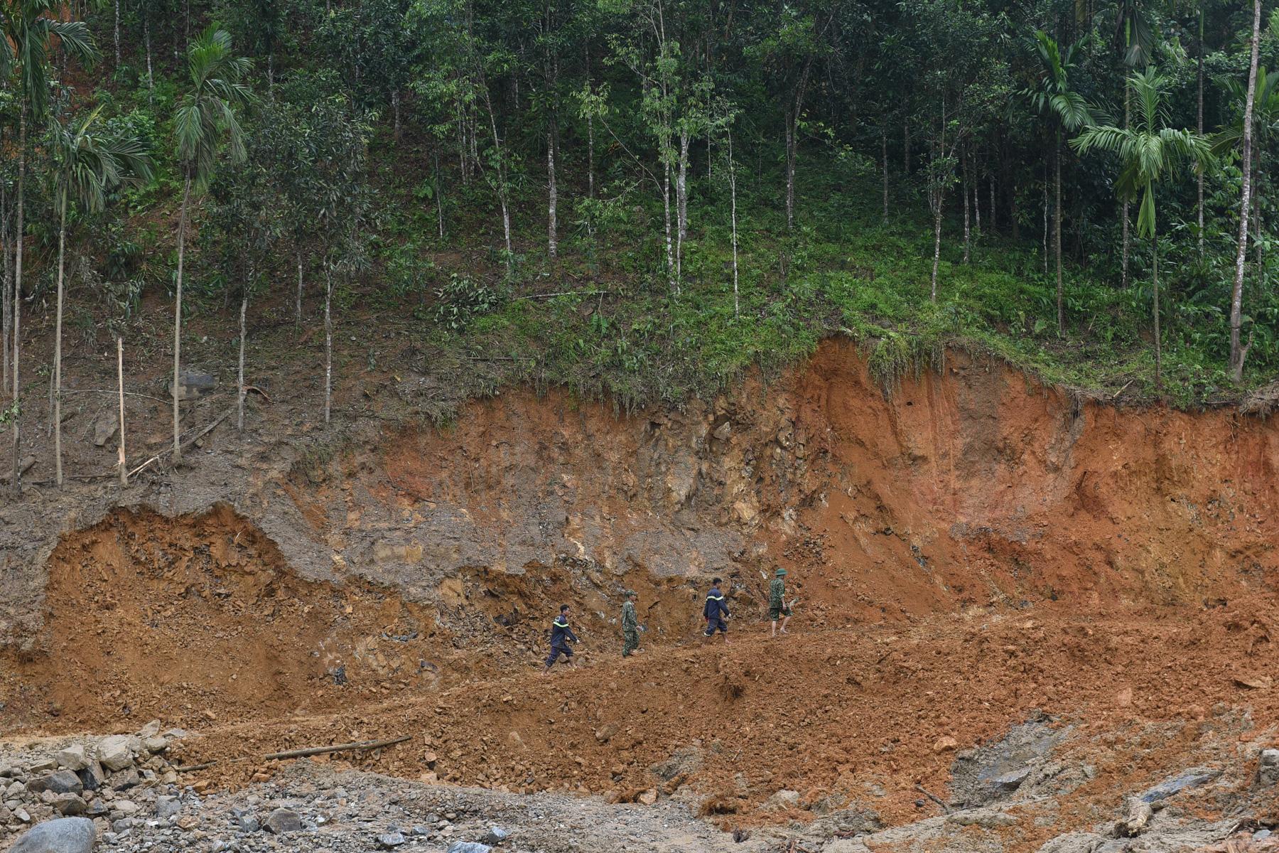 A month with full of sorrow - Rescuers search an area after the landslide in Nam Tra My...