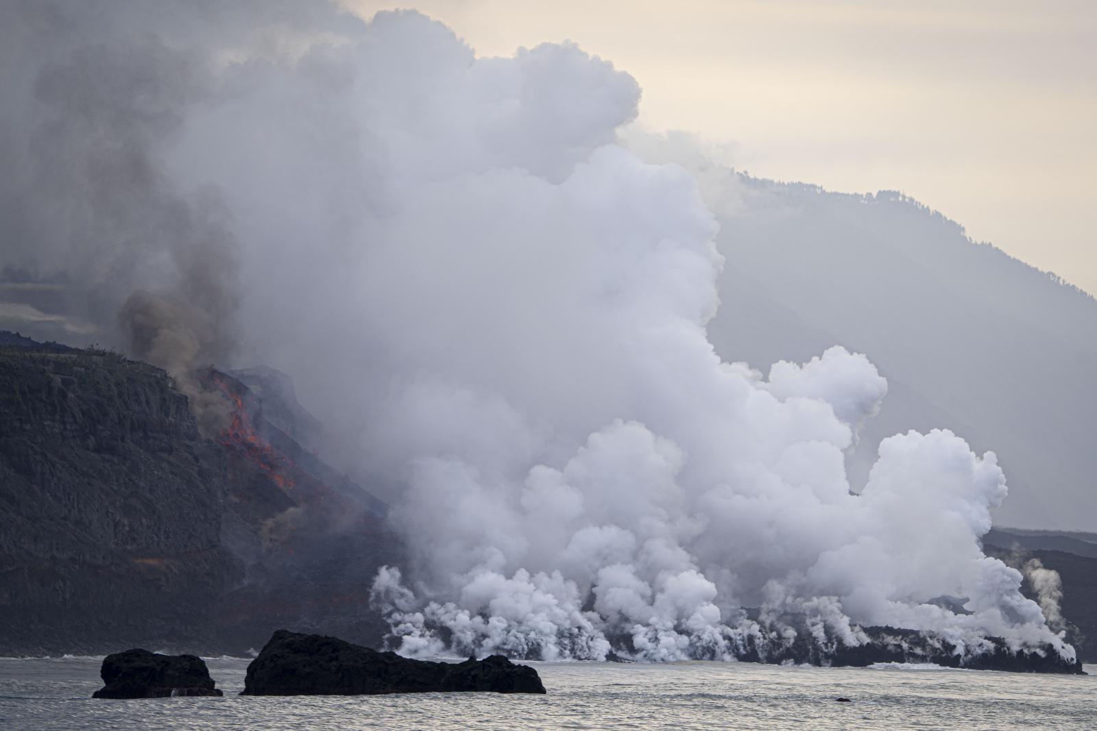 Under the cloud -  The Cumbre Vieja volcano's lava crashes into the...