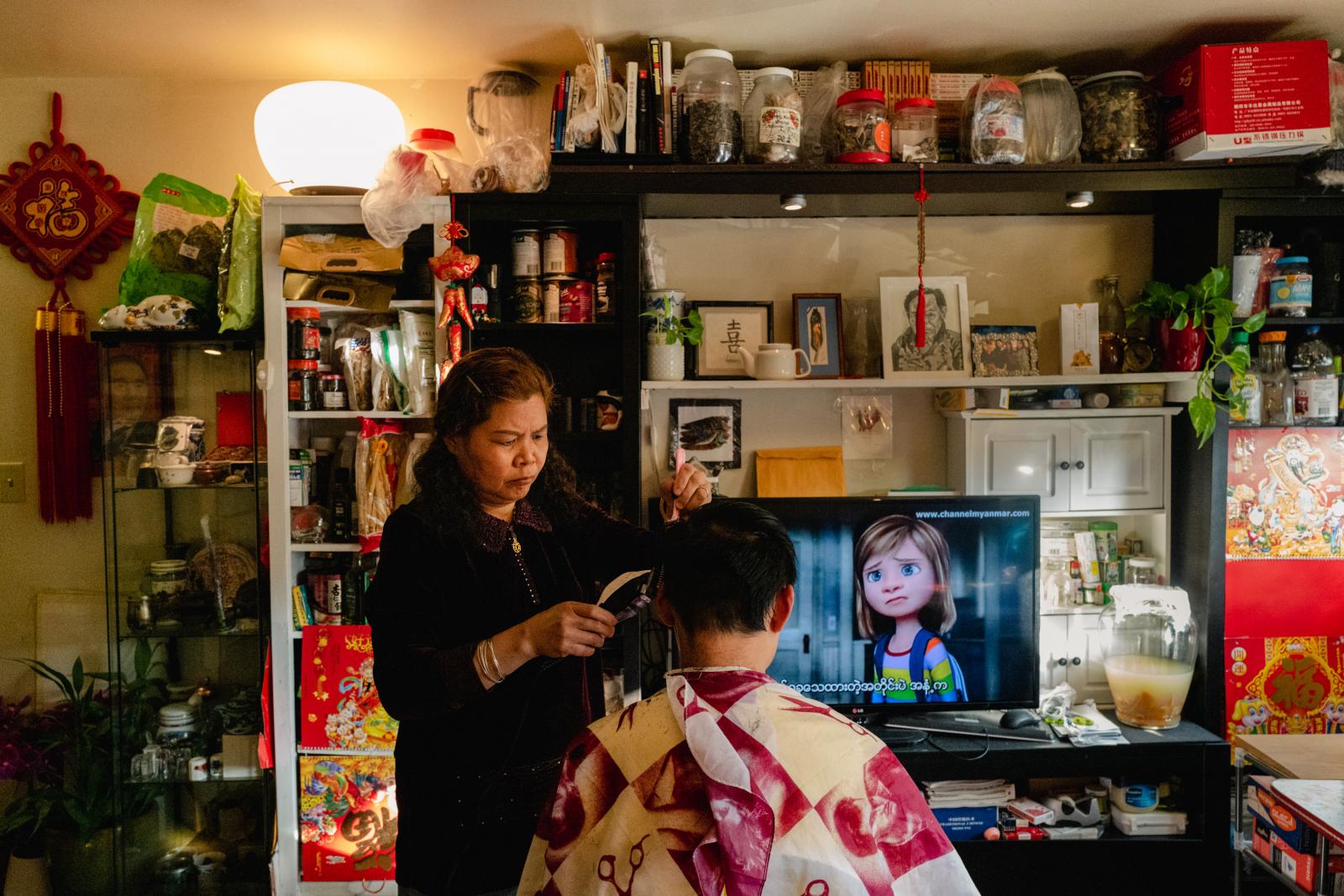 Image from NPR: Two Cantonese Women's Journey: A response to Atlanta Spa Shootings -  Liang gives her son, Jackie, a haircut. 