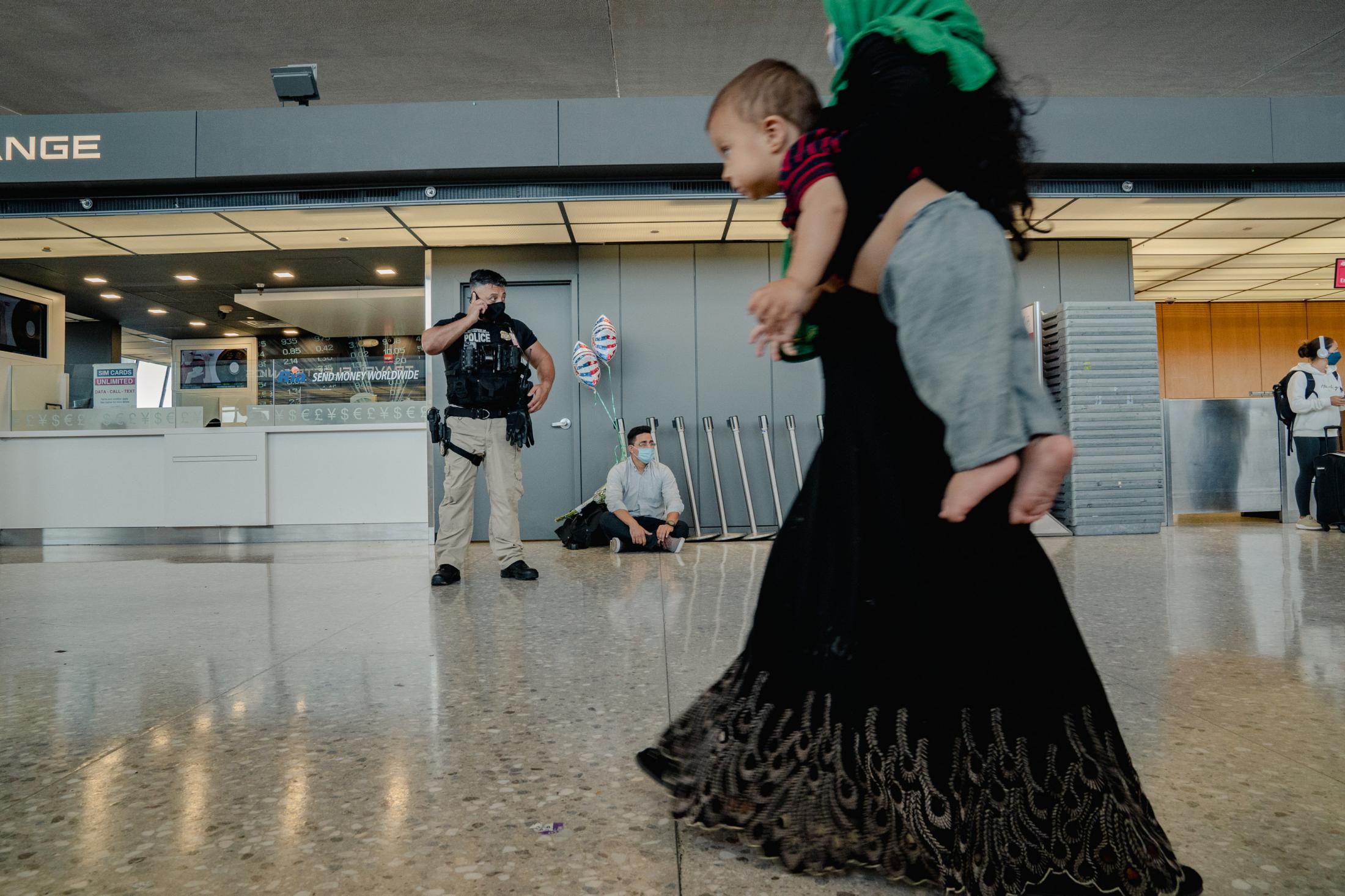 Ajmal patiently waits for the arrival of his wife and two daughters after a year of separation at Dulles International Airport in Dulles, Va., on...