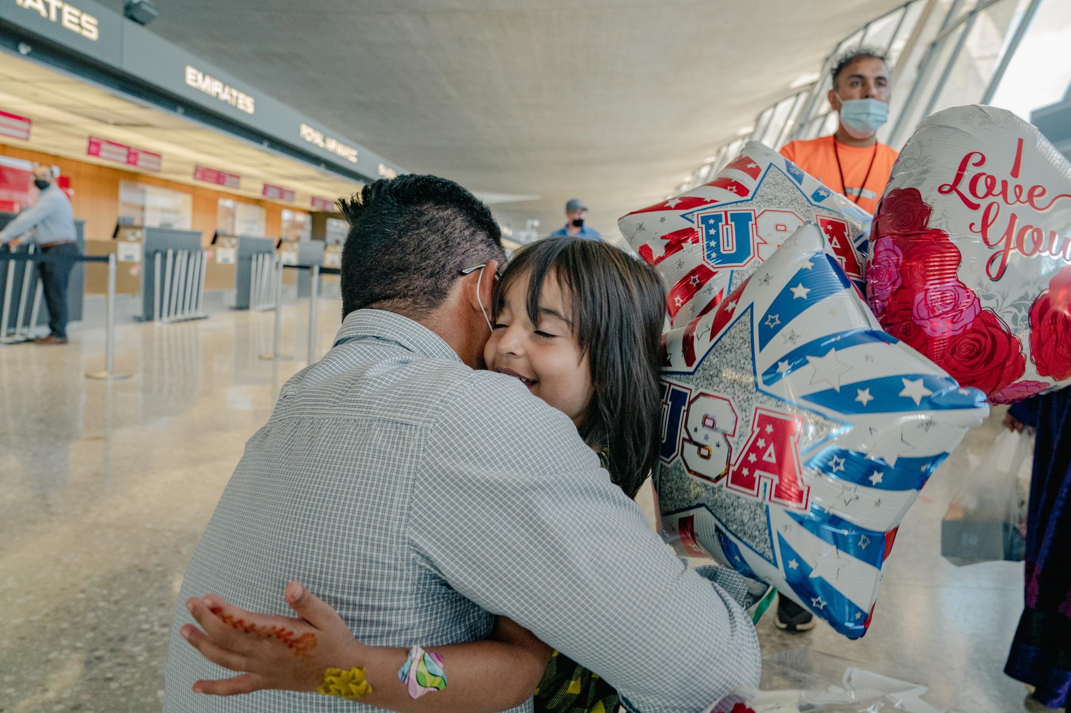 An U.S. Army Afghan interpreter reunites with his family - Ajmal and his oldest daughter embrace at Dulles...