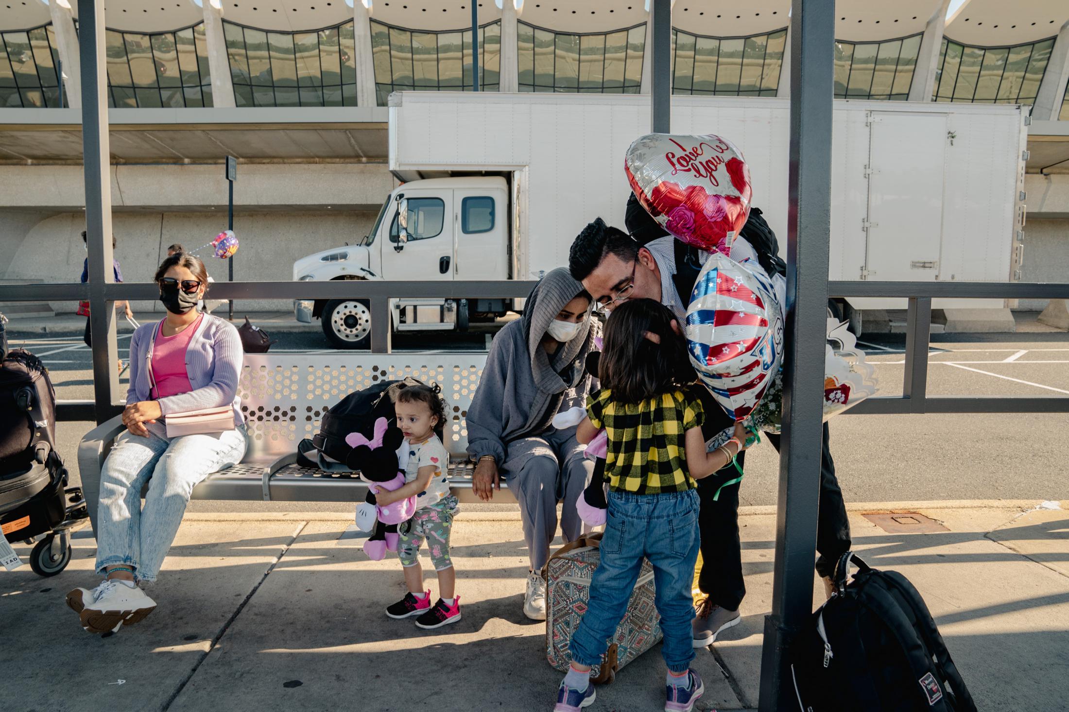An U.S. Army Afghan interpreter reunites with his family - Ajmal gives his older daughter a kiss before the hotel...