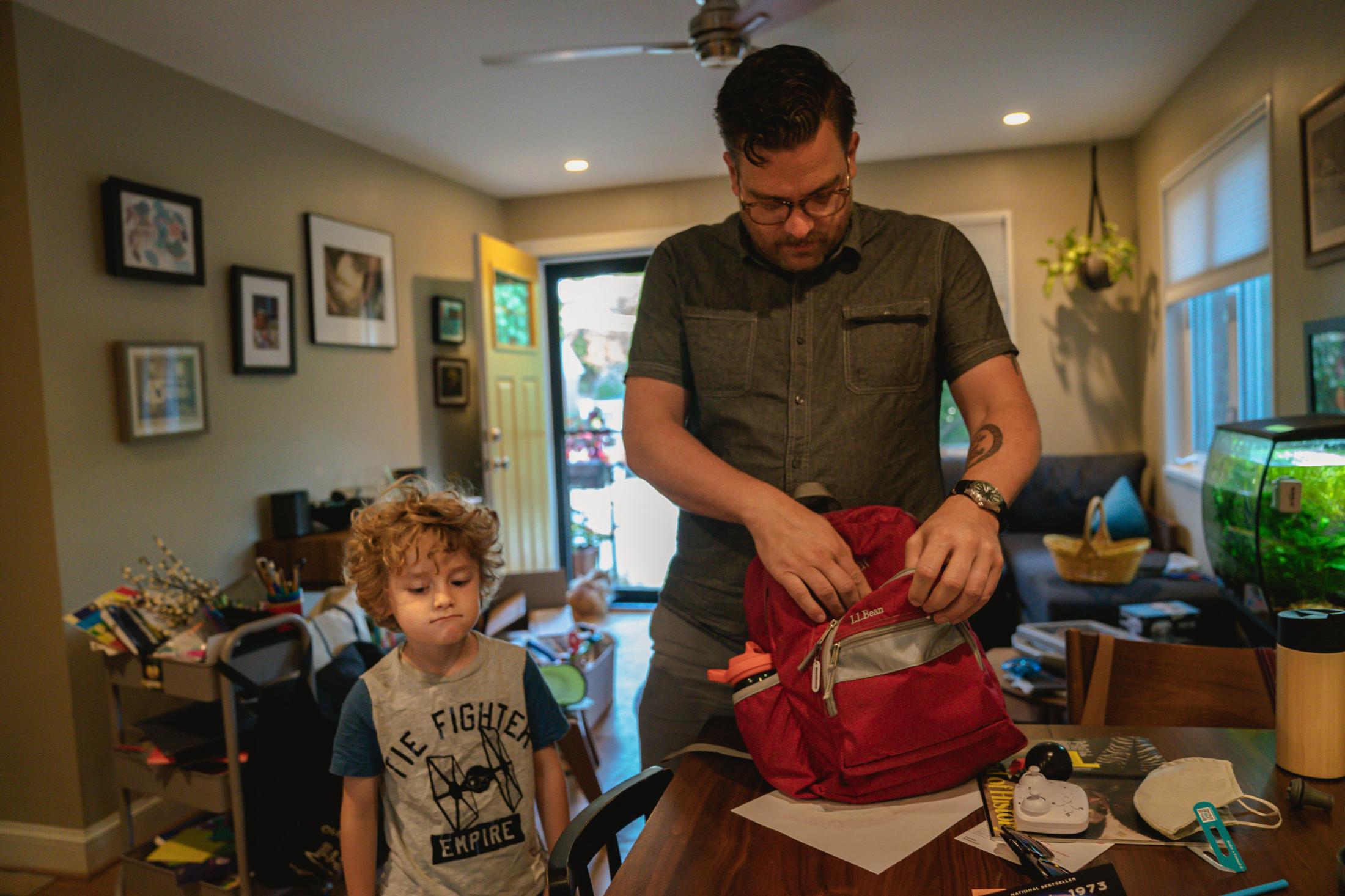 Peter helps Oscar prepare for his backpack in his house in Arlington, VA on Friday, September 15, 2021.