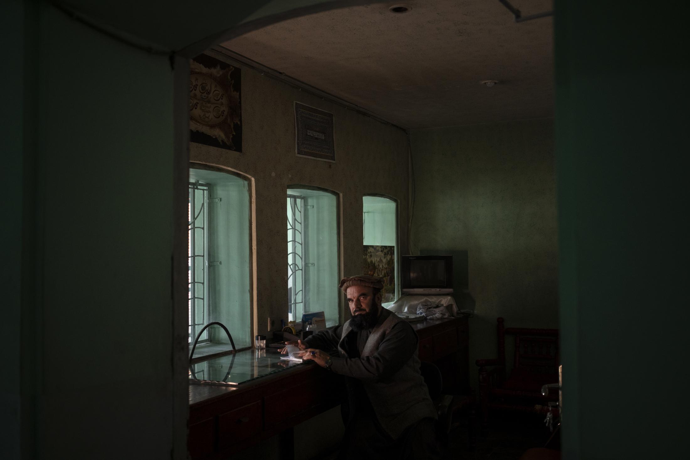 Abdul Malik Wahidi, who sells tickets at Ariana Cinema, poses for a photograph in the ticketing office in Kabul, Afghanistan, Thursday, Nov. 4,...