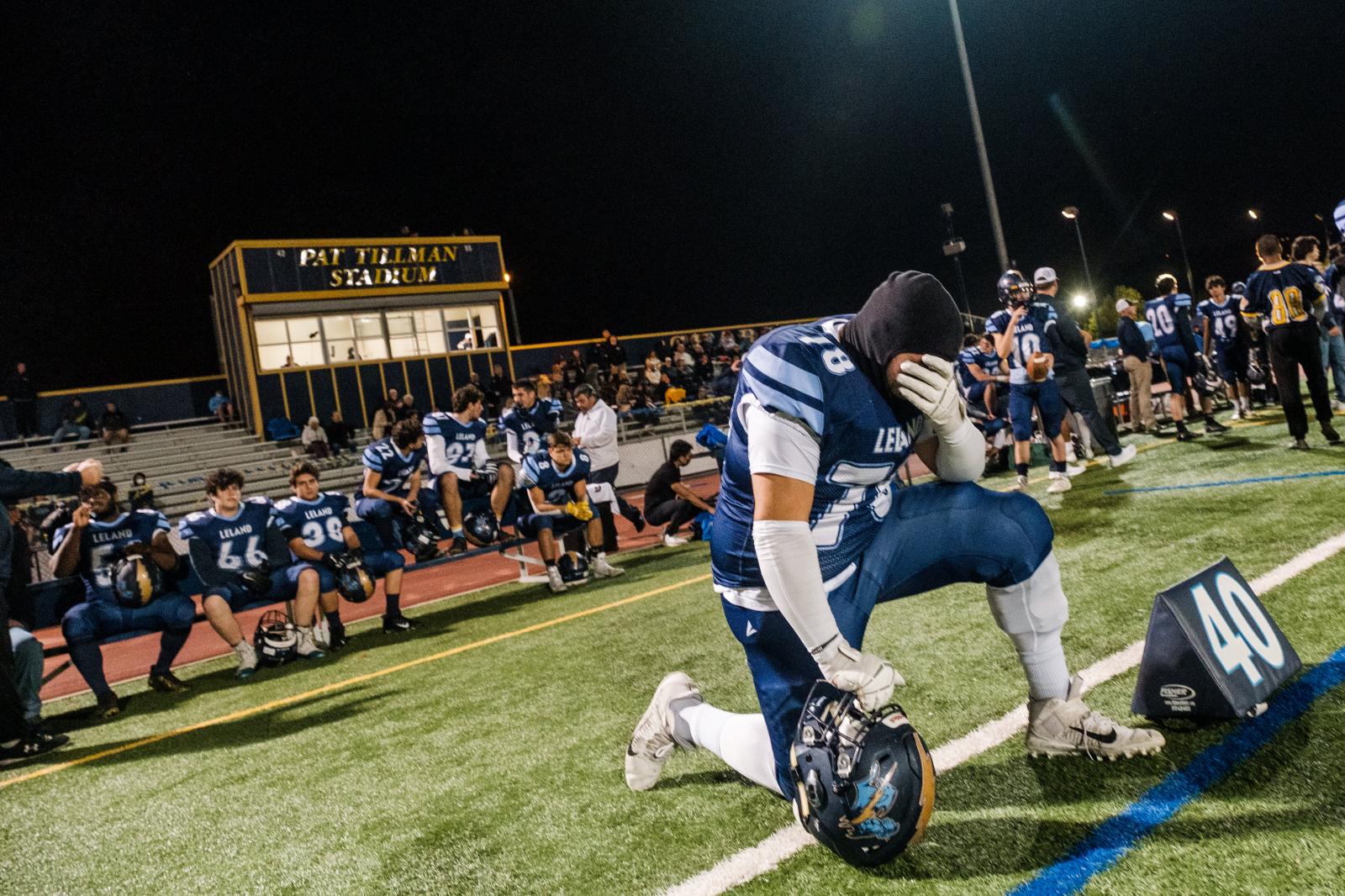 Image from SPORTS - A Leland High School football player pauses before the...