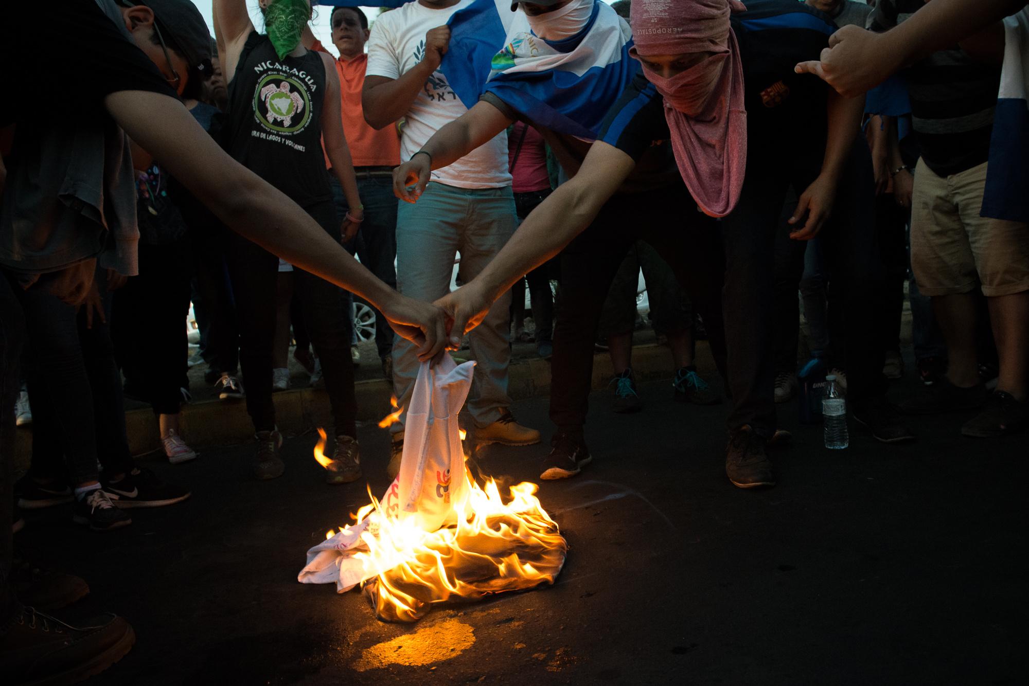 SOS Nicaragua - Protesters burn Juventud Sandinista (JS) t-shirts in...